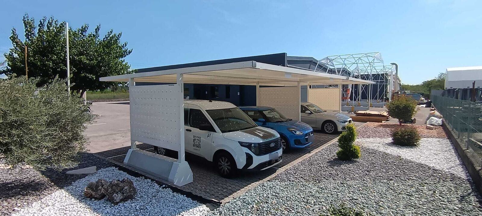 Pensilina KopriAuto con furgone e auto parcheggiati sotto la copertura